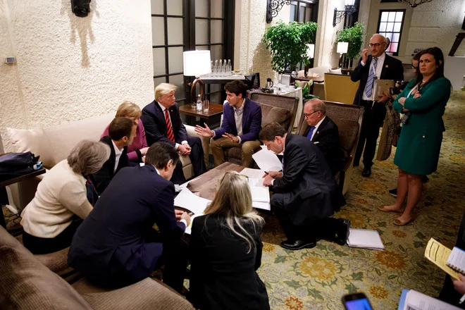 Canada's Prime Minister Justin Trudeau and G7 leaders France's President Emmanuel Macron, Germany's Chancellor Angela Merkel, Britain's Prime Minister Theresa May and U.S. President Donald Trump hold a meeting with staff on the first day of the G7 meeting in Charlevoix city of La Malbaie, Quebec, Canada, June 8, 2018. Picture taken June 8, 2018. Adam Scotti/Prime Minister's Office/Handout via REUTERS. ATTENTION EDITORS - THIS IMAGE WAS PROVIDED BY A THIRD PARTY.