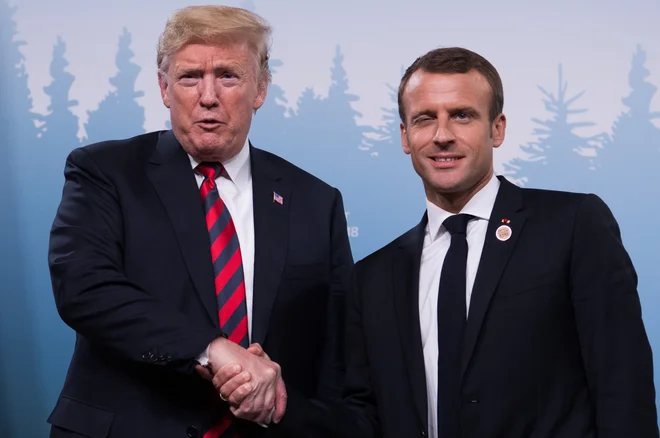 Stiks roke Donalda Trumpa in Emmanuela Macrona. FOTO: Ludovic Marin/AFP