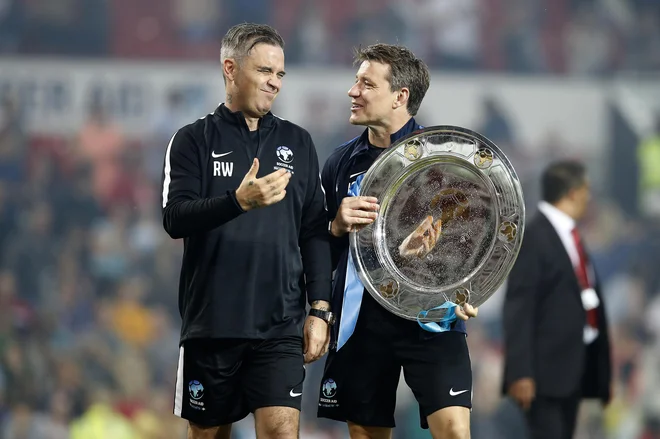 Robbie Williams (levo) na dobrodelni tekmi v Angliji. Foto Martin Rickett Ap