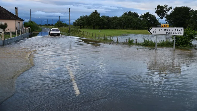 Motorist, ki se pelje po poplavljeni cesti na jugozahodu Francije. FOTO: Jean-francois Monier/AFP