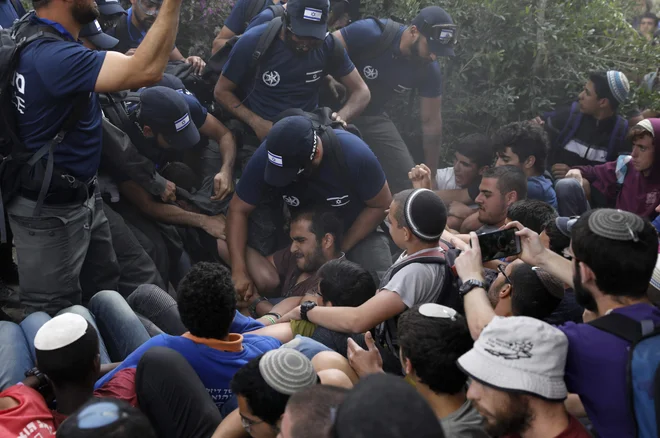 Izraelska policija prisilno izseljuje Izraelce v predelu Netiv Havot v Elazarju, ki leži južno od Jeruzalema, saj morajo zapustili naselje, deloma zgrajeno na palestinskem ozemlju, pred bližajočim se sodnim rokom. Zaradi tega so bili tudi množični protesti. FOTO: Menahem Kahana/AFP