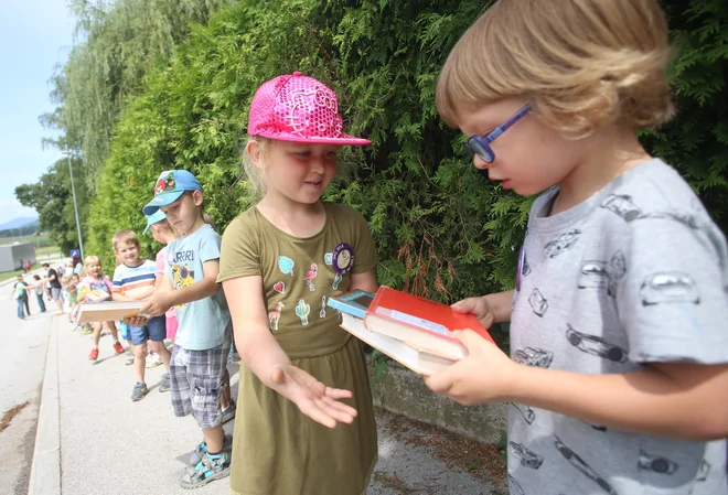 Pri selitvi knjig so pomagali tudi najmlajši iz vrtca. FOTO: Tadej Regent/Delo