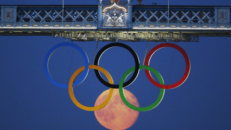 Fotografija: The full moon rises through the Olympic Rings hanging beneath Tower Bridge during the London 2012 Olympic Games August 3, 2012.  REUTERS/Luke MacGregor  (BRITAIN - Tags: SPORT OLYMPICS ENVIRONMENT CITYSPACE)