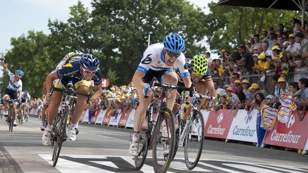 Fotografija: US Tyler Farrar (C) sprints as he crosses the finish line with second-placed France's Romain Feillu (L) and third-placed Spain's Jose Joaquin Rojas (R) at the end of the 198 km and third stage of the 2011 Tour de France cycling race run between Olonne-sur-Mer and Redon, western France, on July 4, 2011.     AFP PHOTO / NATHALIE MAGNIEZ
