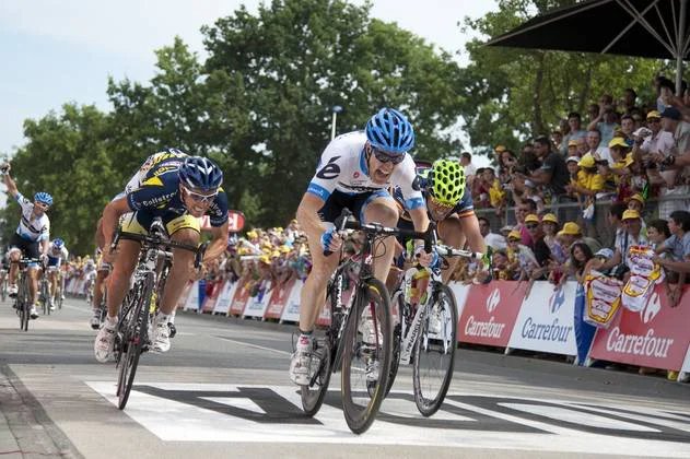 US Tyler Farrar (C) sprints as he crosses the finish line with second-placed France's Romain Feillu (L) and third-placed Spain's Jose Joaquin Rojas (R) at the end of the 198 km and third stage of the 2011 Tour de France cycling race run between Olonne-sur-Mer and Redon, western France, on July 4, 2011.     AFP PHOTO / NATHALIE MAGNIEZ
