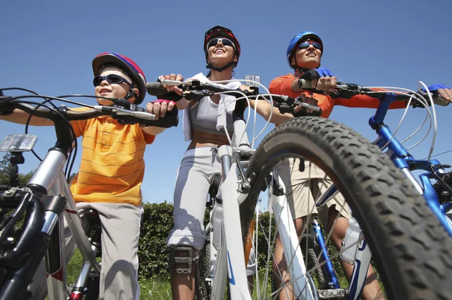 Portrait of happy family on bicycles against blue sky