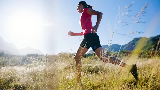 Fit female athlete enjoying trail running in the morning.