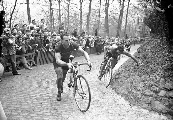 6th April 1952 - Tour of Flanders - Rik van Steenbergen pushes his bike up the Mur de Grammont as other riders struggle behind - Photo: Offside / L'Equipe.