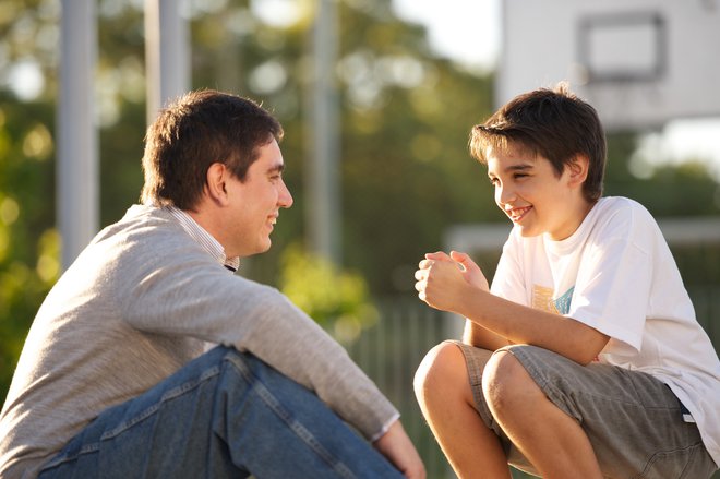 A father and son talking together in an outdoor setting.  Shot in Argentina.