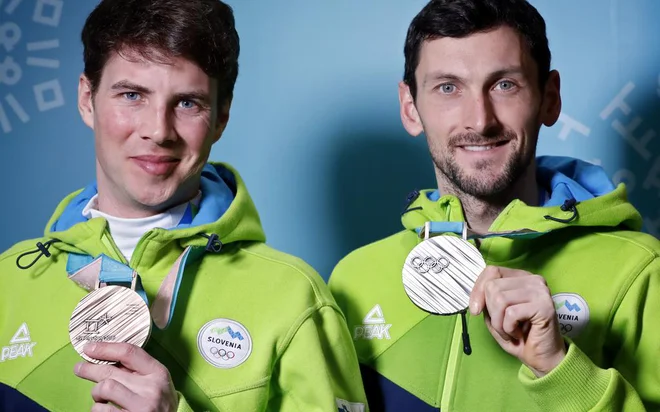 Slovenska junaka &ndash; Jakov Fak (desno) je s srebrom na posamični biatlonski preizkušnji na 20 km osvojil 20. slovensko kolajno na zimskih olimpijskih igrah, 21. je pripadla Žanu Koširju, bronastemu v deskarskem paralelnem veleslalomu. FOTO: Matej Družnik/Delo