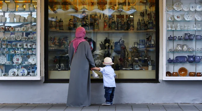 Priseljenka pred trgovino v bavarskem Garmisch-Partenkirchu. FOTO: Reuters