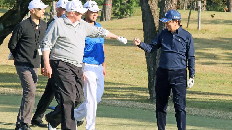 Fotografija: Donald Trump pozdravlja dobro potezo Šinza Abeja (desno) med njuno zadnjo partijo golfa. FOTO: Reuters