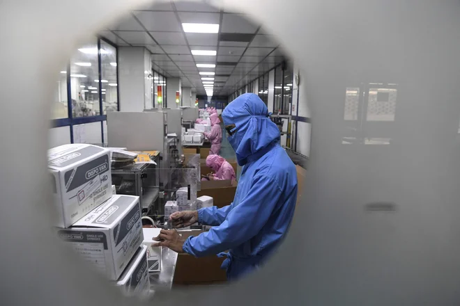 Evropska komisija je sklenila pripravljalne pogovore s podjetjema BioNTech in Pfizer za nakup do 300 milijonov odmerkov potencialnega cepiva proti covidu-19. FOTO: Sajjad Hussain/AFP
