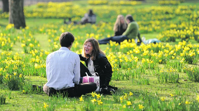 People sit in the sunshine in St James's park in central London.