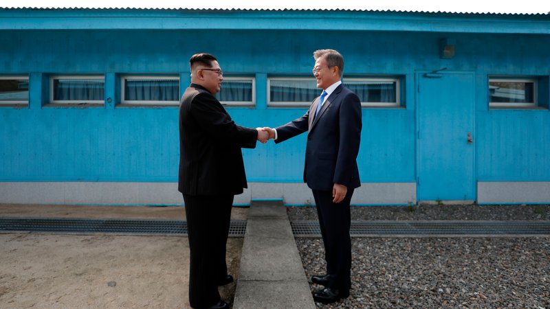 Fotografija: Voditelja Severne Koreje Kim Džong Un in Južne Koreje Mun Dže In sta si segla v roko. FOTO: AFP