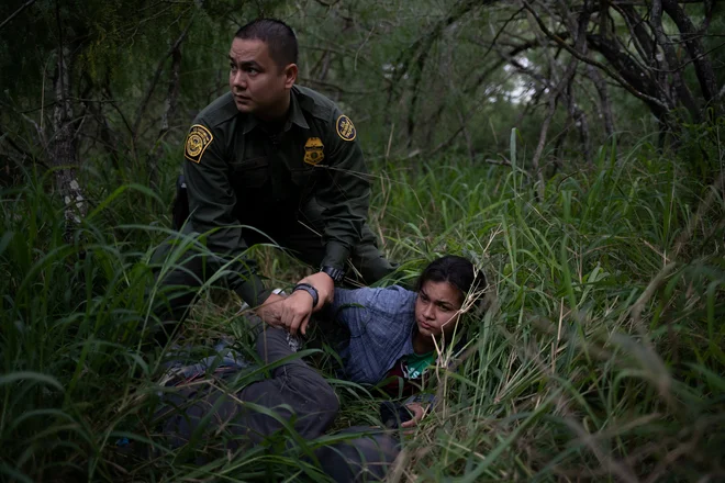 Agent mejne patrulje med ZDA in Mehiko je ujel žensko in moškega med nezakonitim prečkanjem meje v bližini obmejnega ameriškega mesta McAllen v Teksasu. FOTO: Adrees Latif/Reuters