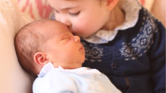 Fotografija: Spečemu malčku poljubček daje njegova sestrica, princesa Charlotte. FOTO: Kensingtonska Palača