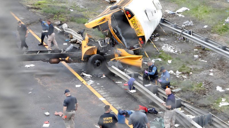 Fotografija: V ameriški zvezni državi New Jersey sta trčila šolski avtobus, poln petošolcev, in tovornjak z nagibnim kesonom oziroma prekucnik. Grozljiva nesreča se je zgodila med šolskim izletom osnovnošolcev. V trčenju sta umrla najmanj dva človeka, še 45 jih je poškodovanih. Med smrtnimi žrtvami je bil tudi otrok. FOTO: Mike Segar/Reuters