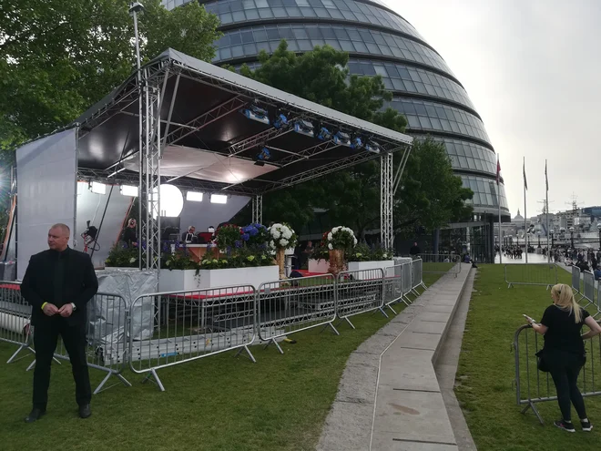 V bližini London Towerja je s cvetjem okrasen oder s komentatorji kraljevske poroke. FOTO: Mitja Felc/Delo