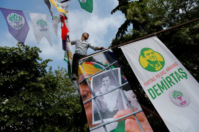 Podporniki kurdske Demokratične ljudske stranke obešajo plakate zaprtega sovoditelja stranke Selahattina Demirtaşa. FOTO: Reuters