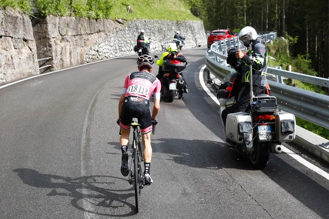 Rožnati majici v gorah vsi gledajo v hrbet. FOTO: Luk Benies/Afp