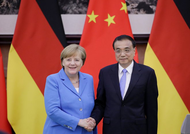 Kitajski premier Li Keqiang se rokuje z nemško kanclerko Angelo Merkel. FOTO: Jason Lee/Reuters