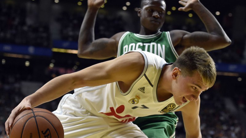 Fotografija: Real Madrid's Slovenian guard Luca Doncic (down) vies with Boston Celtics' guard Terry Rozier (Up) during their NBA Global Games Madrid 2015 basketball match Real Madrid vs Boston Celtics at the Barclaycard center in Madrid on October 8, 2015. AFP PHOTO/ GERARD JULIEN Foto Gerard Julien Afp