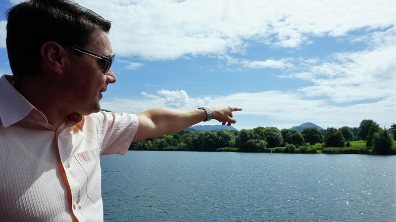 Fotografija: Velenjski podžupan Peter Dermol kaže, kje na Velenjskem jezeru angleški investitor načrtuje hotel na vodi. Foto: Brane Piano/DELO