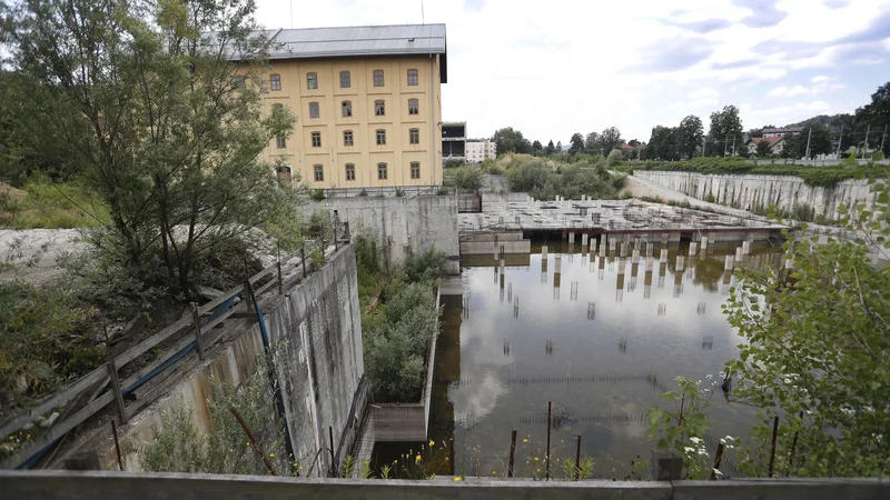 Fotografija: Gradbena jama v Tobačni zeva že nekaj let, zdaj pa bo najverjeteje dobila novega lastnika. Avstrijska družba EWO - Bauträger  je namreč za nakup ponudila 25 milijonov evrov. FOTO: Leon Vidic 