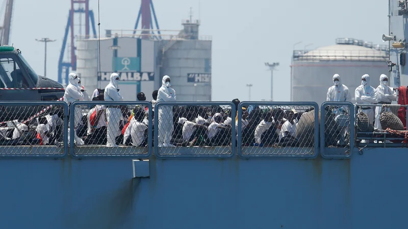 Fotografija: TOPSHOT - Migrants sit on the deck of the Italian navy ship Orione as the ship enters the port of Valencia on June 17, 2018.
The Aquarius rescue ship with more than 600 people on board, has been the heart of a major migration row between European Union member states. / AFP PHOTO / PAU BARRENA