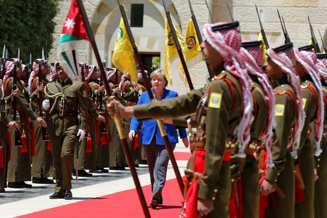 Kanclerka Angela Merkel med pregledom častne straže v kraljevi palači v Amanu . FOTO: Reuters