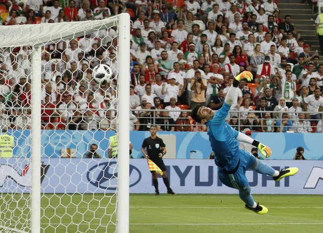 Iranski vratar Ali Beiranvand je bil prekratek ob mojstrovini Ricarda Quaresme. Foto Pavel Golovkin/AP