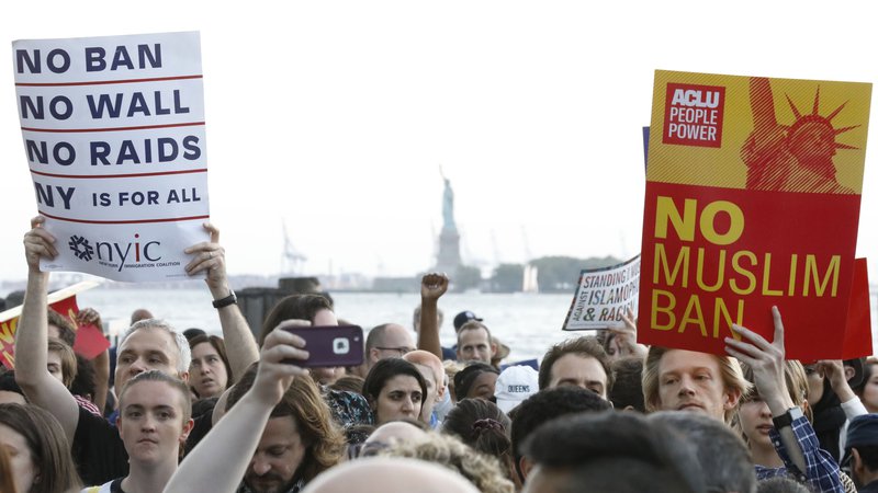 Fotografija: Na skrajnem jugu Manhattna, v parku Battery, je včeraj množica ljudi protestirala proti Trumpovi politiki priseljevanja. FOTO: Reuters