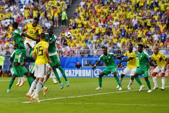 Yerry Mina (najvišji v skoku) je s svojim drugim golom na SP v Rusiji Kolumbijo popeljal v osmino finala. Foto Manan Vatsyayana/Afp
