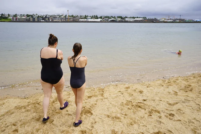 Nekatere tudi slabo vreme in nizke temperature ne ustavijo. Na fotografiji se dve želita kopati v morju z le 10 °C v Reykjaviku. FOTO: Egill Bjarnason/AP