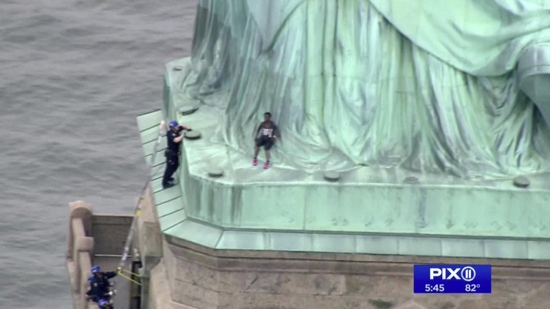 Fotografija: Turisti so morali zapustiti kip, medtem ko je ženska vztrajala pri nogah simbola svobode. FOTO: AP