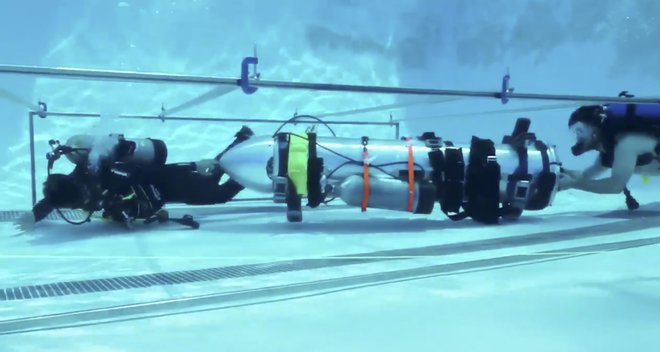 Ekipa Elona Muska v bazenu preizkuša podmornico, s katero bi morda lahko rešili ujete otroke. FOTO: Ap
