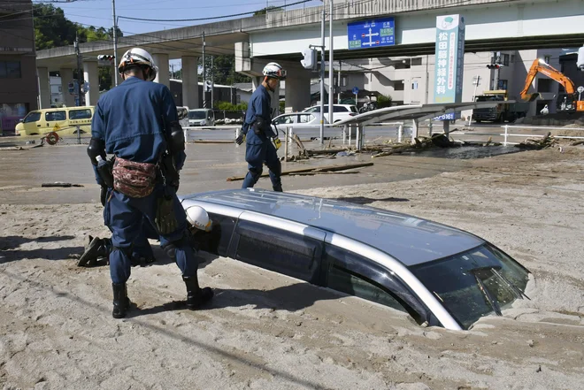 Policisti pregledujejo tudi zasute avtomobile. FOTO: AP