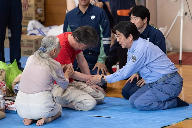 Japonski premier Shinzo Abe ima veliko dela, obiskal je že nekatere oškodovance poplav. FOTO: AFP
