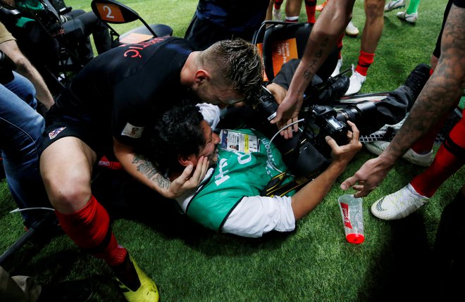 Nogometaši pomagajo Cortezu, ki se je zaradi evforije hrvaških nogometašev znašel na tleh stadiona. FOTO: Carl Recine/Reuters