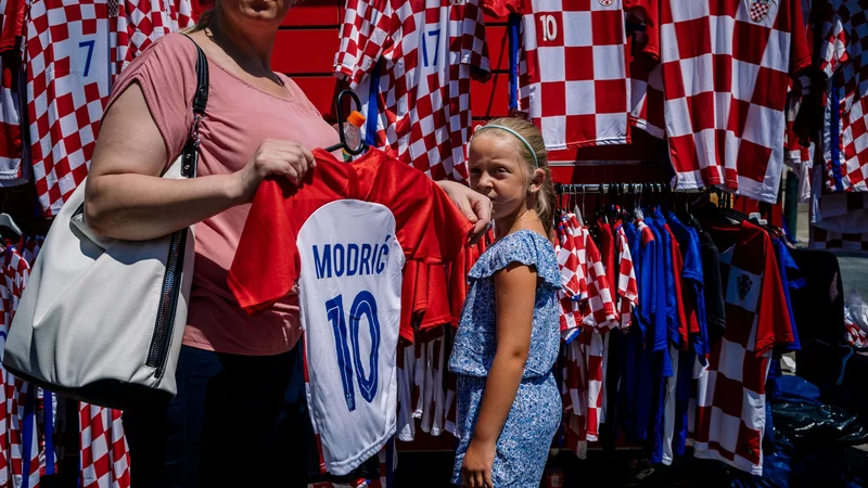 Fotografija: V Zagrebu imajo te dni, tako je bilo tudi na to soboto pred finalom, prodajalci dresov in majic hrvaške nogometne reprezentance polne roke dela. FOTO: AFP