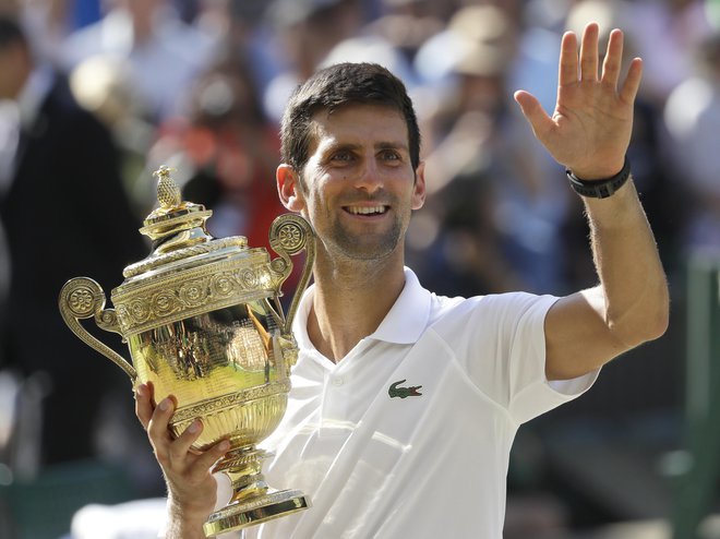 Srbski teniški igralec Novak Đoković je že četrtič slavil v Wimbledonu. FOTO: Ben Curtis Ap
