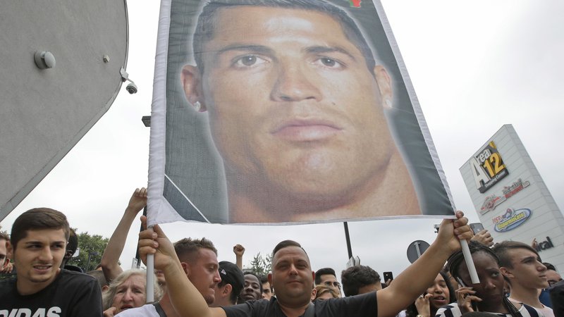 Fotografija: Juventusovi navijači so svojega novega junaka Cristiana Ronalda pričakali pred štadionom, kjer so tudi dvignli plakat z njegovo podobo. Foto AP