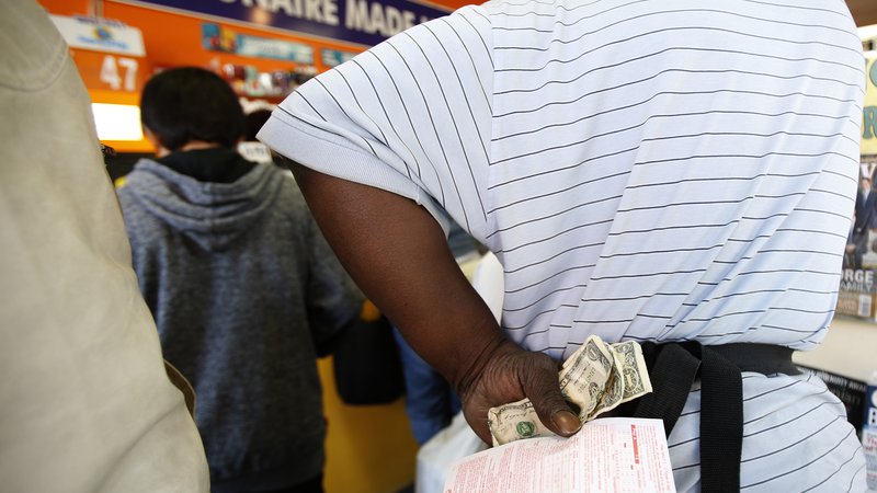 Fotografija: Ljudje v vrsti čakajo na nakup loterijske srečke. FOTO: Mario Anzuoni/Reuters