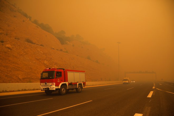 Zaradi močnega dima, ki se vije vzhodno od turističnega kraja proti Atenam, so morali preventivno zapreti avtocesto med Korintom in Atenam. FOTO: Reuters