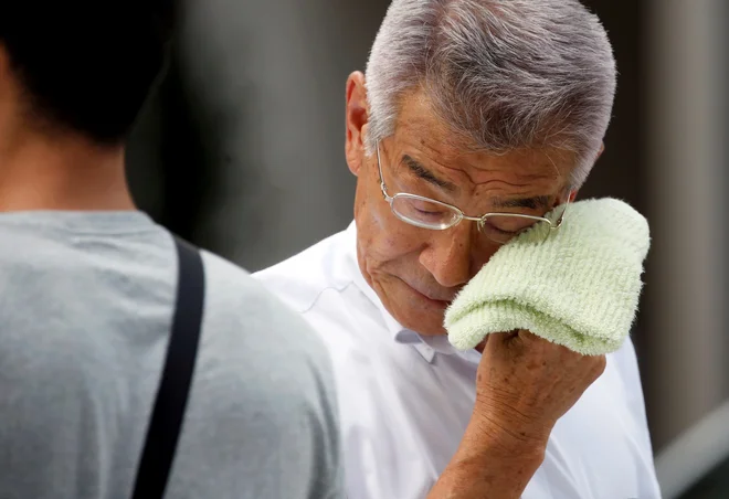 Vročinski val je Japonsko zajel po močnem deževju ter poplavah in plazovih, v katerih je življenje izgubilo več kot 220 ljudi. FOTO: Issei Kato/Reuters