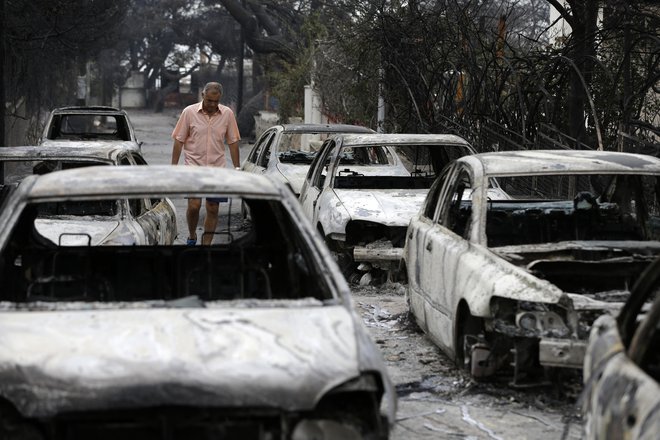 Grčija je skozi EU zaprosila za mednarodno pomoč, potem ko so ognjeni zublji na obeh straneh prestolnice poškodovali kolone avtomobilov, stavb, farm in gozdov. FOTO: Thanassis Stavrakis/AP