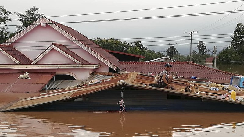 Fotografija: A villager takes refuge on a rooftop above flood waters from a collapsed dam in the Attapeu district of southeastern Laos, Tuesday, July 24, 2018. The official Lao news agency KPL reported Tuesday that the Xepian-Xe Nam Noy hydropower dam in Attapeu province collapsed Monday evening, releasing large amounts of water that swept away houses and made more than 6,600 people homeless. (Attapeu Today via AP)