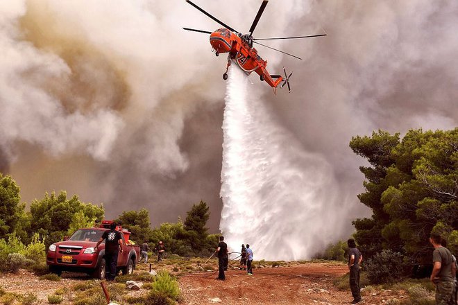 Na pomoč gasilcem je prišel helikopter. FOTO: AFP