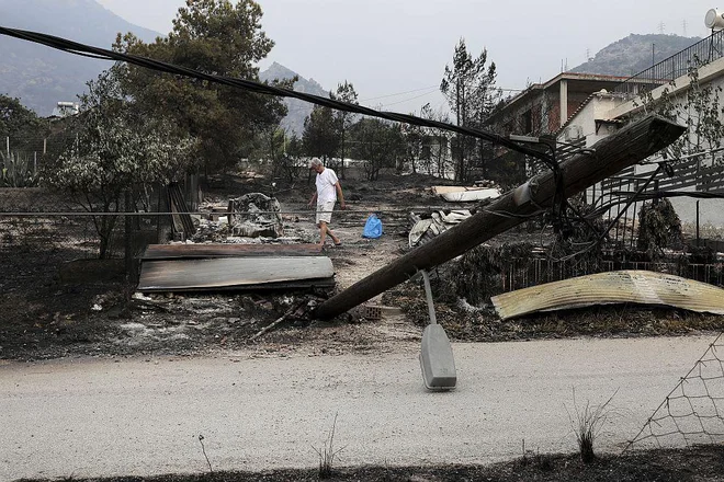 V Kineti moški med ruševinami svojega doma išče, ali je kateri osebni predmet ostal neuničen. FOTO: AP